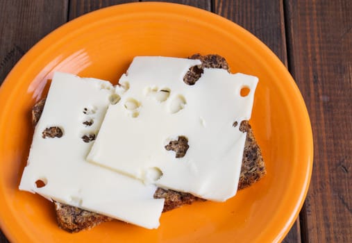 wholemeal rye bread with cheese and orange slice