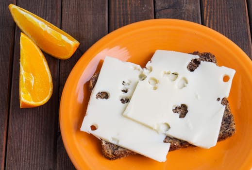 wholemeal rye bread with cheese and orange slice
