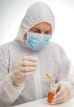 Man testing lab sample in protective suit and mask