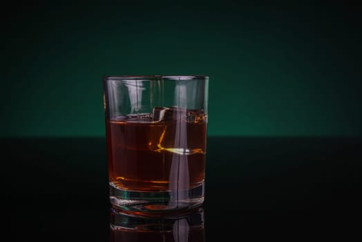 A glass of whisky or rum, with green backlight