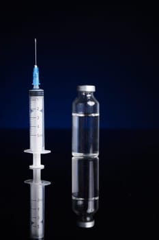 Syringe and medical vial, with blue background