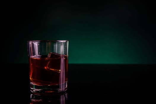 A glass of whisky or rum, with green backlight