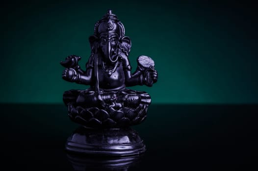 Statue of the Hindu God Ganesha with green background