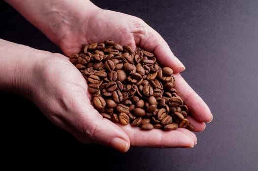 Hands holding Coffee Beans isolated on Black