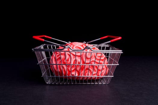 Think before you Bye. Brain and shoppingcart isolated on Black
