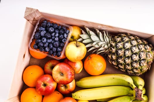 Wood Crate filled with Organic ripe fruit isolated on White