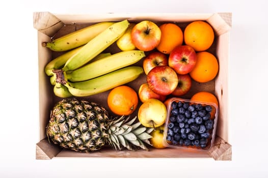 Wood Crate filled with Organic ripe fruit isolated on White