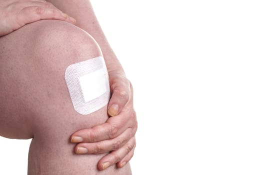 Women with wounds on her knees. The damage is treated with an adhesive bandage , so to prevent the blood from flowing. Isolated on white
