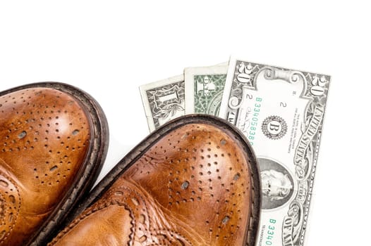 Dollars under a pair of Shoes. Business and Money or the cost of a Date. Isolated on White