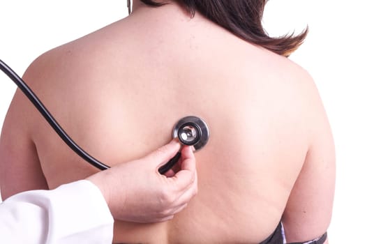 Young woman being investigated for pneumonia by her family doctor . Isolated on white. The picture shows her bare back , doctor's hand and stethoscope