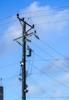 power poles with many wires against the blue sky