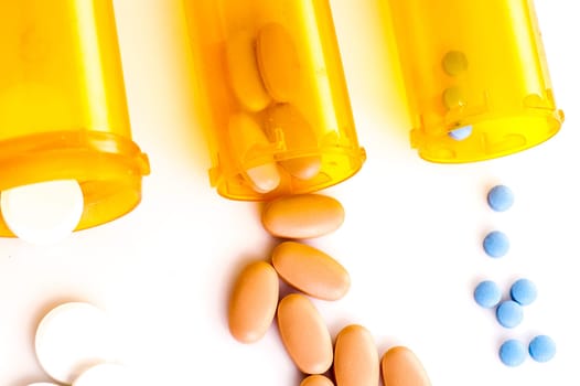 Pill Medicine, white, blue and brown pills lying with the medicine bottle, isolated on white
