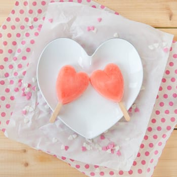 Ice cream on the stem in heart shape with colorful sugar hearts