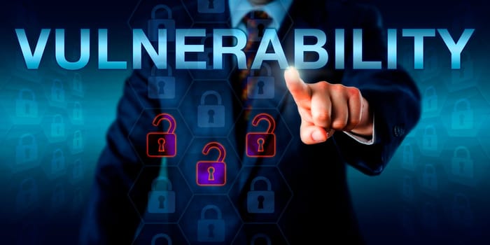 Cyber attacker in business suit is pressing VULNERABILITY onscreen. Three unlocked virtual padlock icons light up in fiery orange to signify the unprotected status of the underlying data matrix.