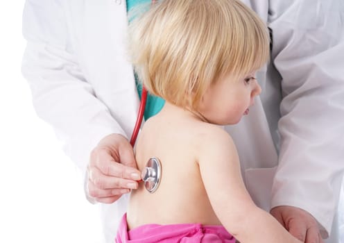 The doctor examines toddler child and listening to heart and lungs with stethoscope. The baby girl is happy, isolated on white