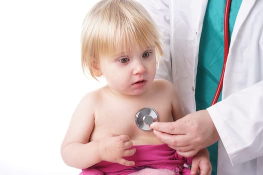 The doctor examines toddler child and listening to heart and lungs with stethoscope. The baby girl is happy, isolated on white