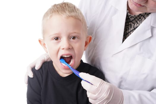 Young Boy gets help by the Dentist to brush his teeth, Isolated on white