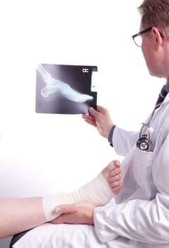 The doctor examines an X-ray picture , while the patient&#39 s sprained foot resting in his hand
