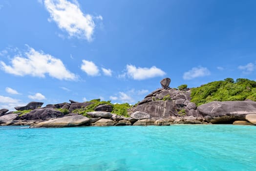 Beautiful landscape rock is a symbol of Similan Islands and people over the blue sea under summer sky in Mu Ko Similan National Park, Phang Nga province, Thailand