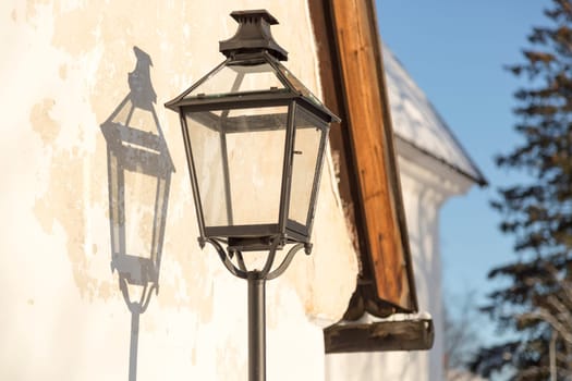 Old Street Light with its shadow on a wall.