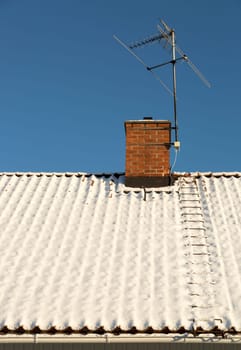 Snow Covered Roof with Chimney and TV Antenna.