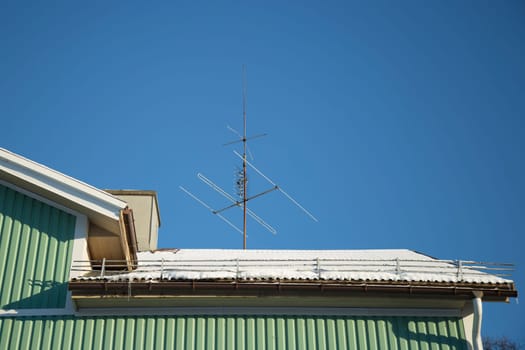 TV Antenna on Snow Covered Roof.