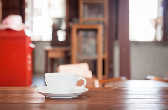 White coffee cup on wooden table in coffee shop