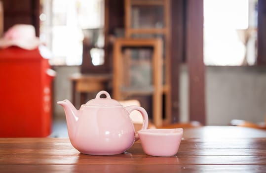 Tea pot on wooden table in coffee shop