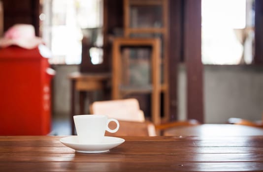 White coffee cup on wooden table in coffee shop