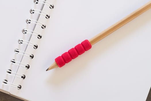 Blank notebook with pencil on grey background, business concept