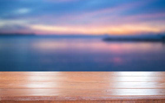 Old empty wooden table top with sunset background