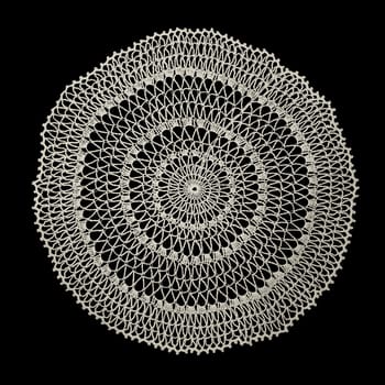 White handmade lace (round form), isolated on black.