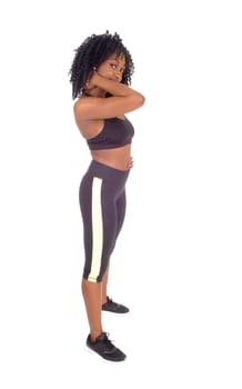 A slime African American woman in black exercise clothing standing in.profile, showing her great figure, isolated for white background..
