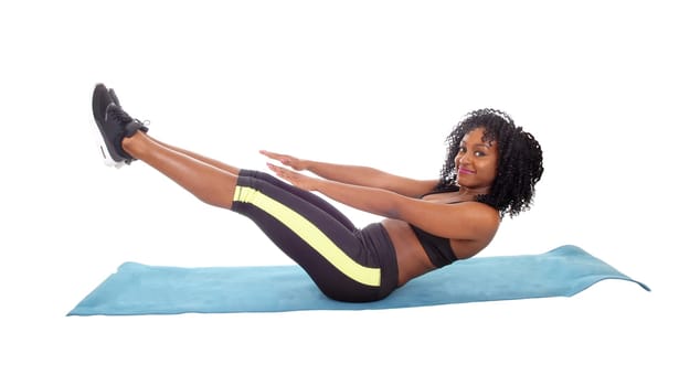 A beautiful young African American woman in exercise outfit sitting on the .floor doing sit-up's, whit legs up, isolated for white background..