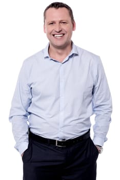 Confident handsome male smiling with hands in pockets