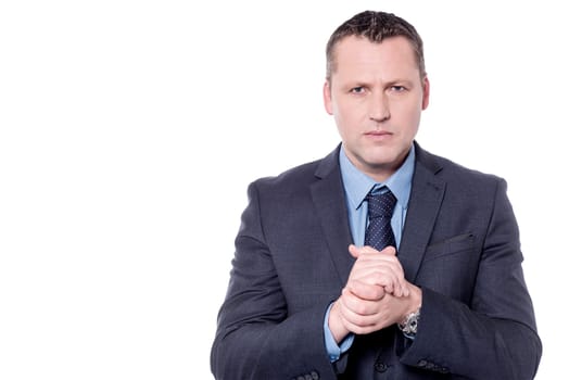 Serious businessman with clasped hands over white