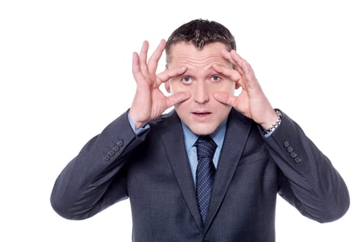 Businessman holding his eyes open with hands