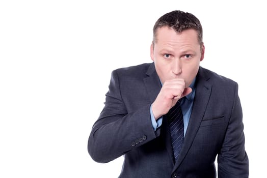 Businessman raising his fist to mouth looking miserable unwell