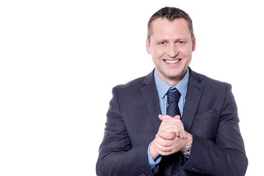 Cheerful businessman posing with his hands clasped