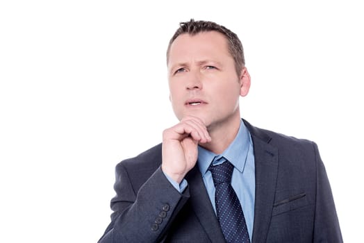 Pensive businessman with hand on chin over white
