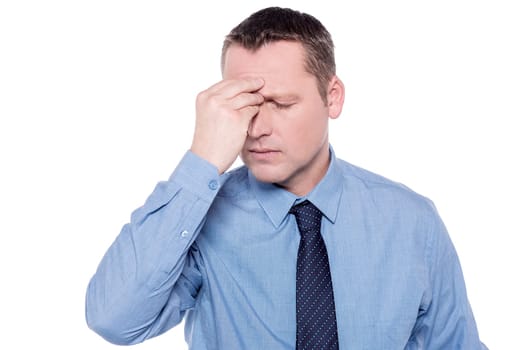 Depressed corporate executive keeping his hand on forehead
