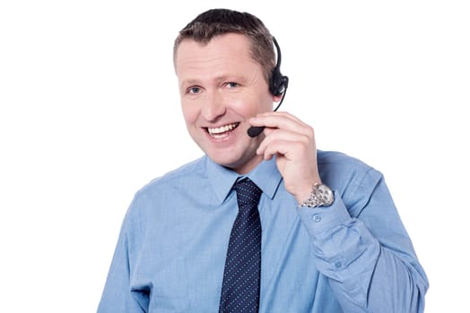 Happy male executive talking with customer using headphone