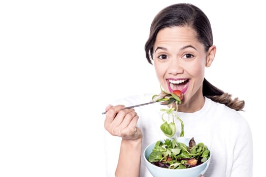 Woman eating a healthy diet with a bowl of green salad