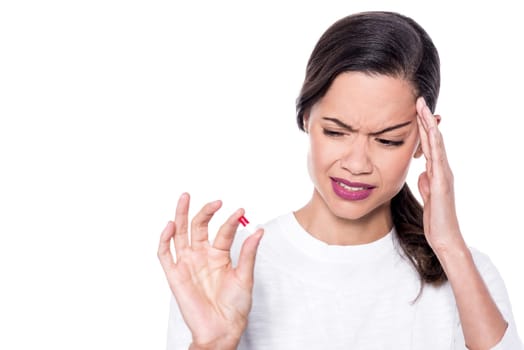 Depressed woman holding a pill in her hand