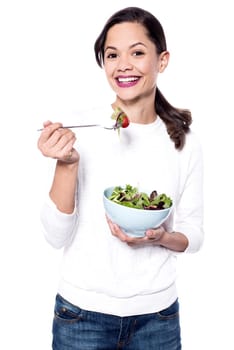 Studio shot of a woman holding delicious green salad