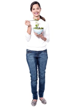 Young woman holding a bowl of fresh green salad