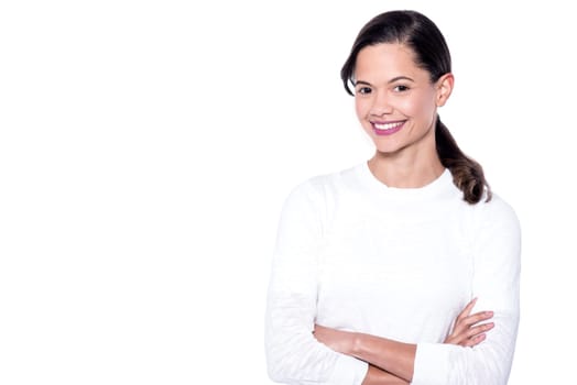 Young girl with a radiant smile, arms crossed