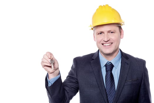 Male architect holding house key over white