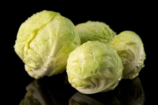 Fresh brussels sprouts isolated on black background.