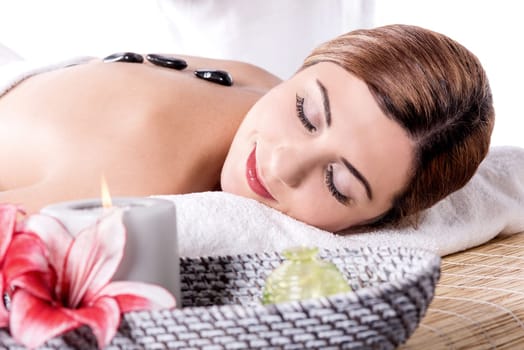 Stone massage for young woman at beauty spa salon